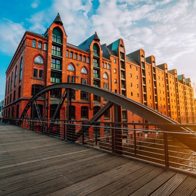 Arch bridge over canals in the Speicherstadt of Hamburg. Warm evening sun light on red brick building